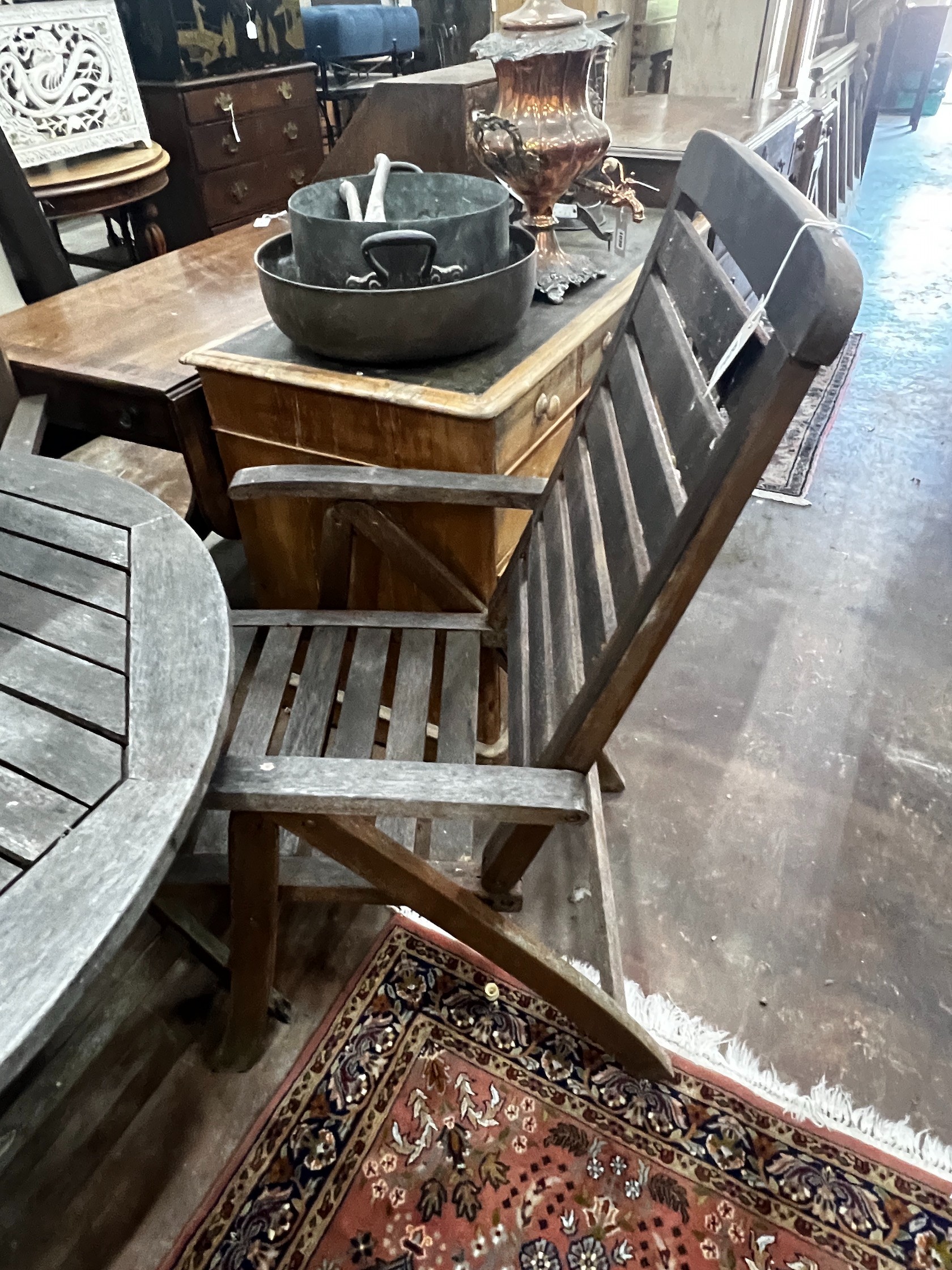 A circular weathered teak folding garden table and four teak folding armchairs, stamped Royal Craft, table 110cm diameter height 74cm